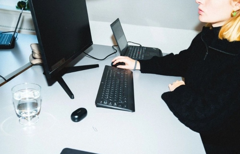 Person sidder foran et skrivebord med en PC