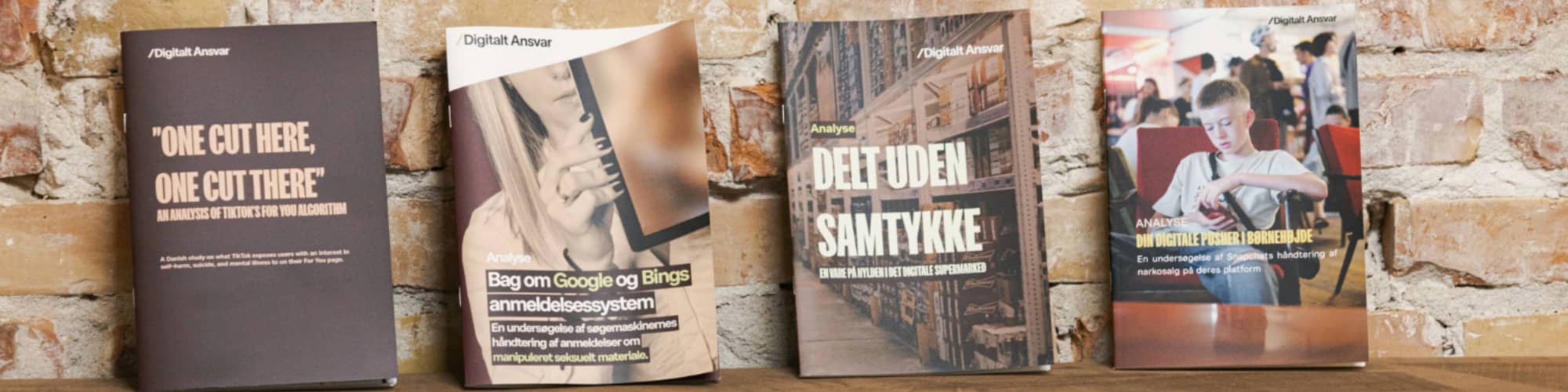 Fire af Digitalt Ansvars publikationer opstillet på en bænk
