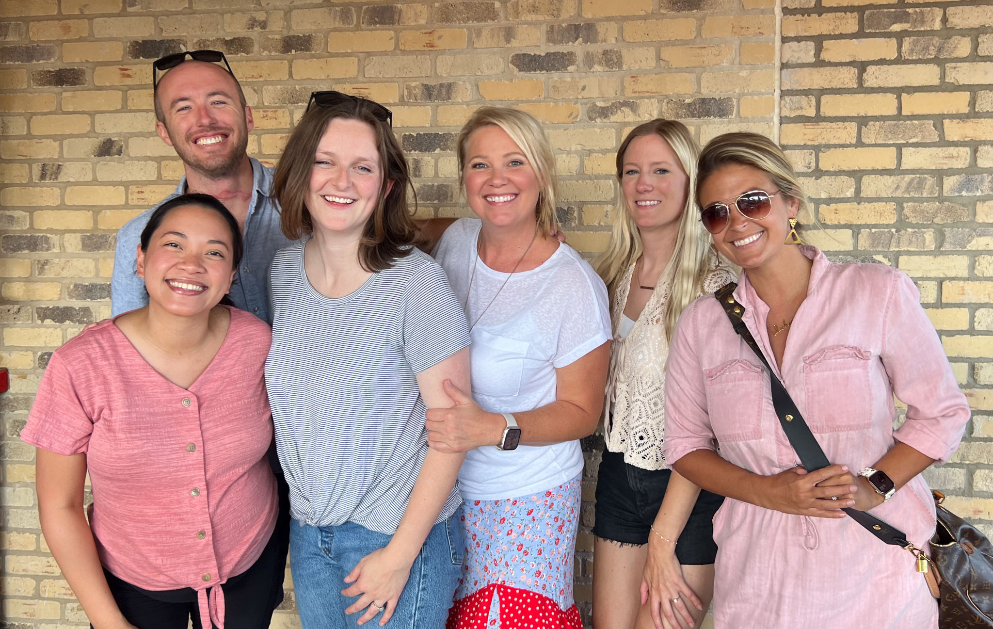 The US team pose in front of a brick wall at the baby shower outing for Lystra and Jess.