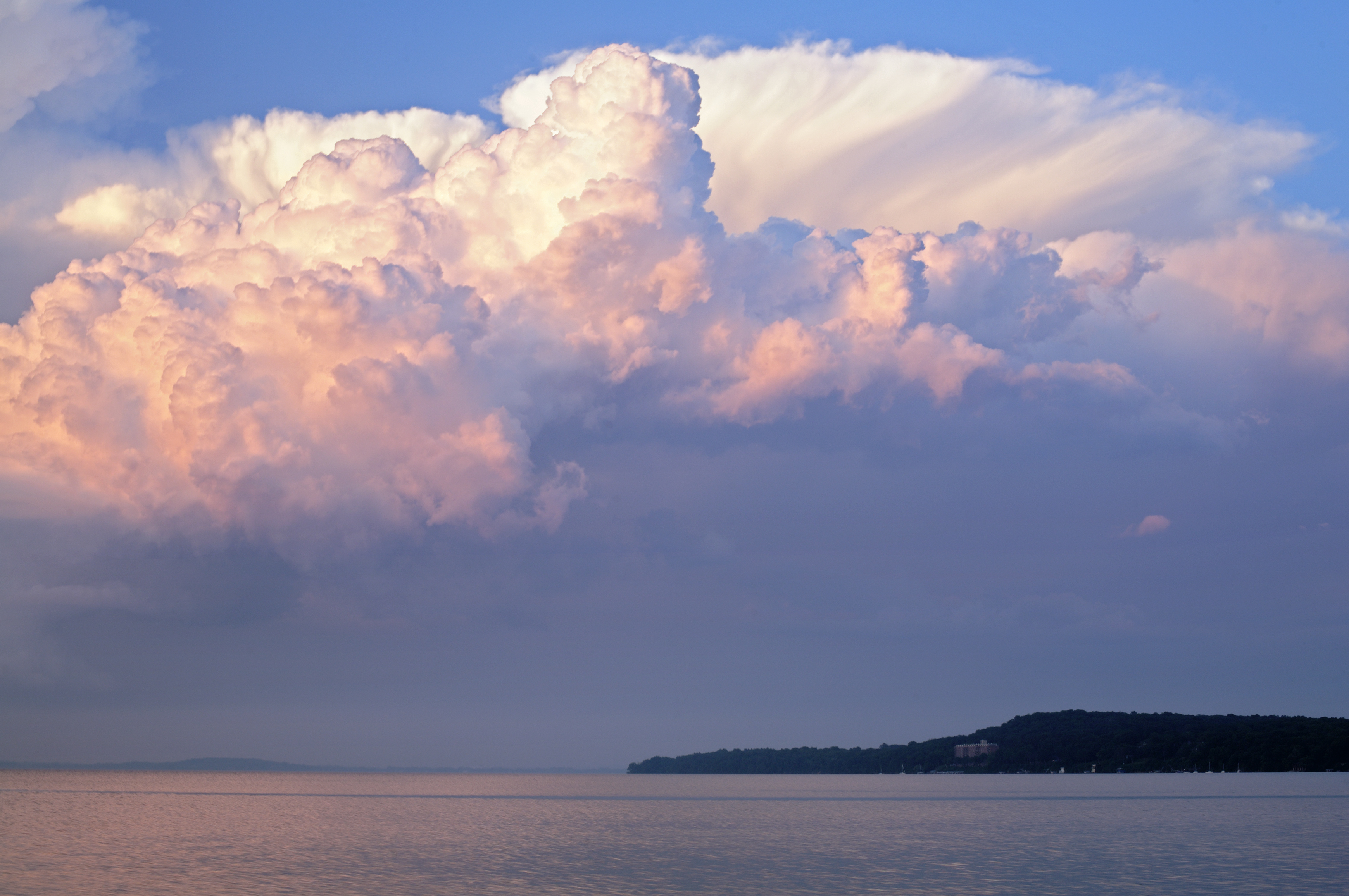 Sunset with fluffy clouds over the lake in Madison Wisconsin showing Picnic Point in the background.