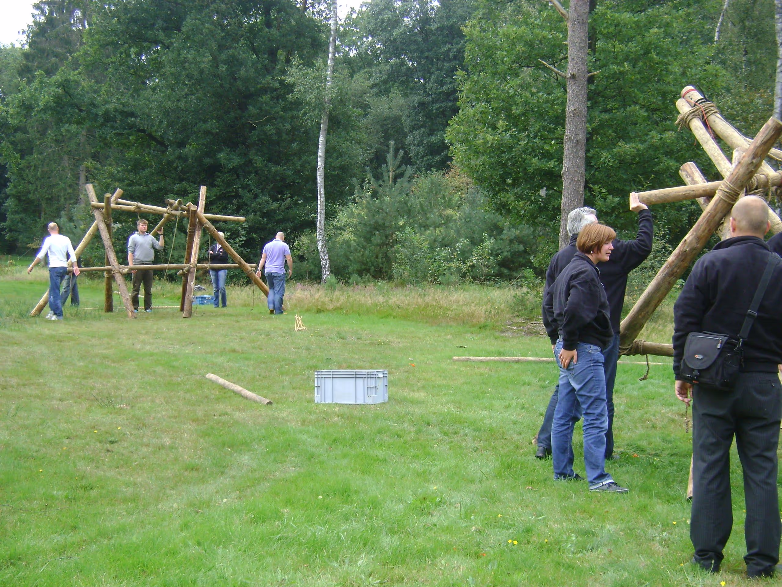 Twee katapulten worden tegenover elkaar gebouwd op een grasveld met in het midden een grijze krat