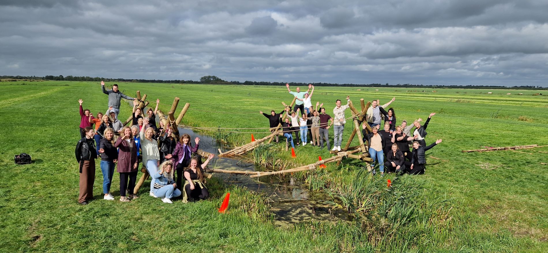 Groepsfoto met de zelfgemaakte brug met alle deelnemers