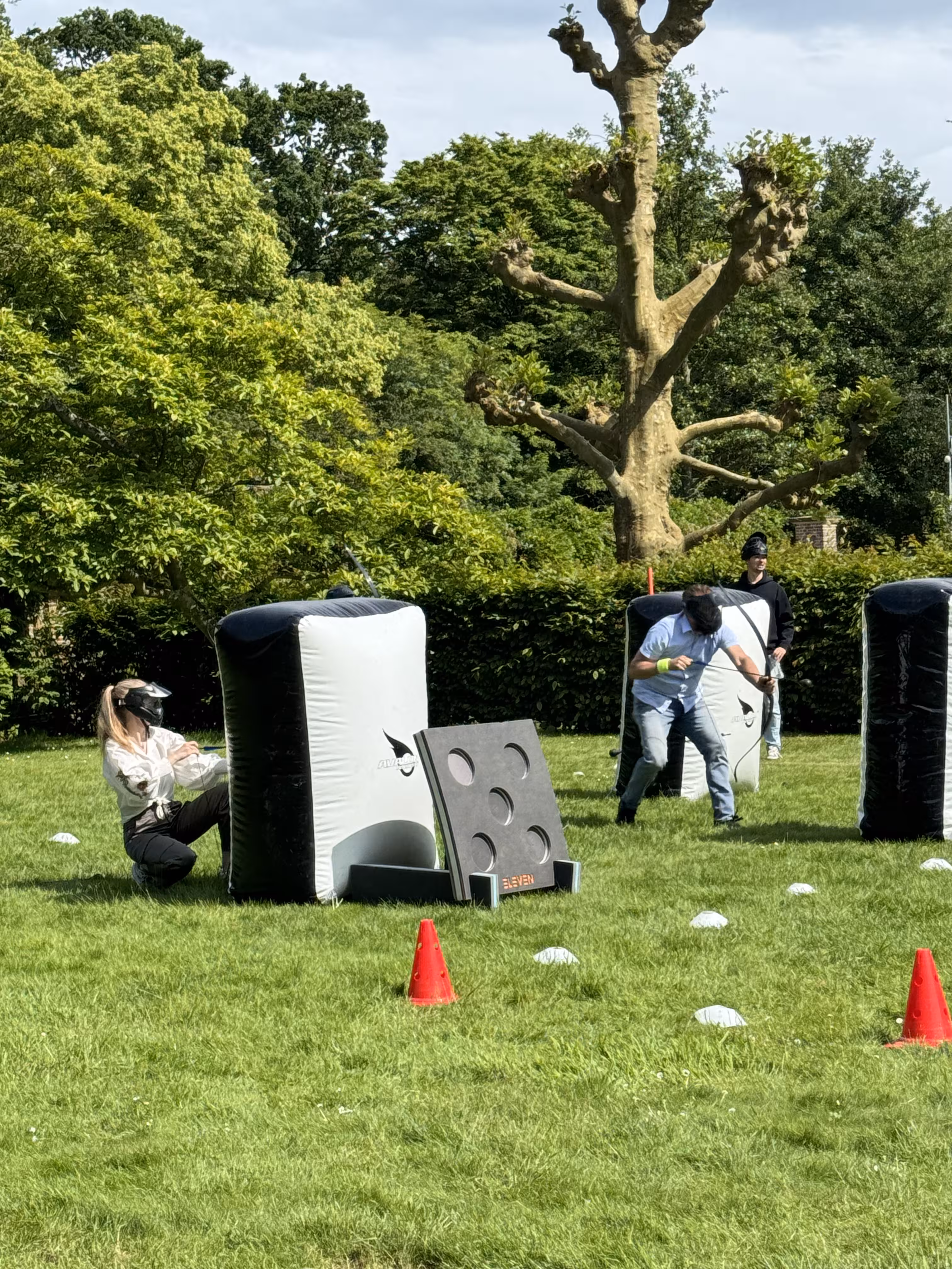 Twee deelnemers zijn aan het schuilen achter de opblaasbare obstakels 