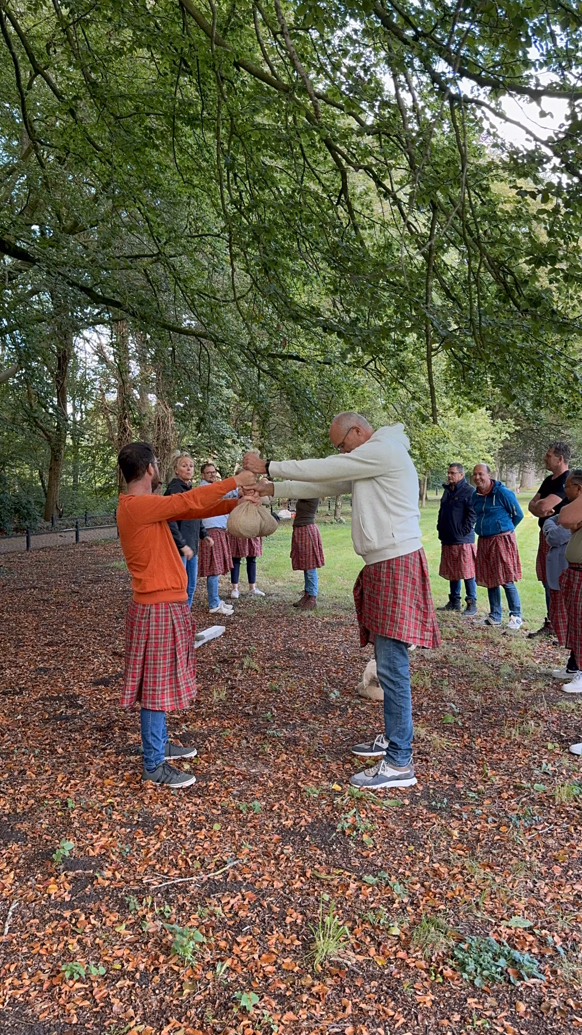 Er worden twee jute zakken getild door twee mannen met gestrekte armen