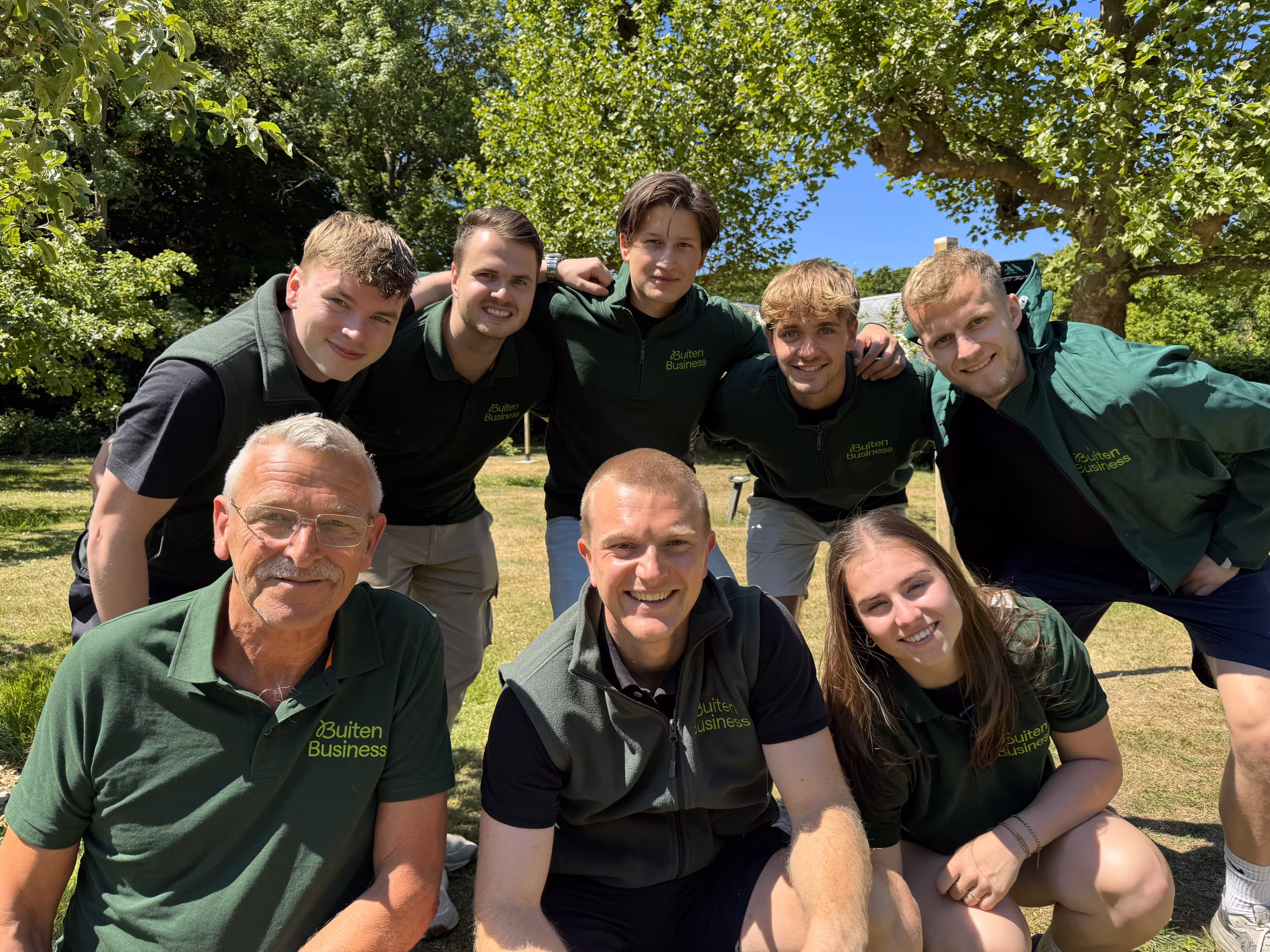 Acht BuitenBusiness instructeurs die de outdoor Teamwork verzorgen in een groene omgeving