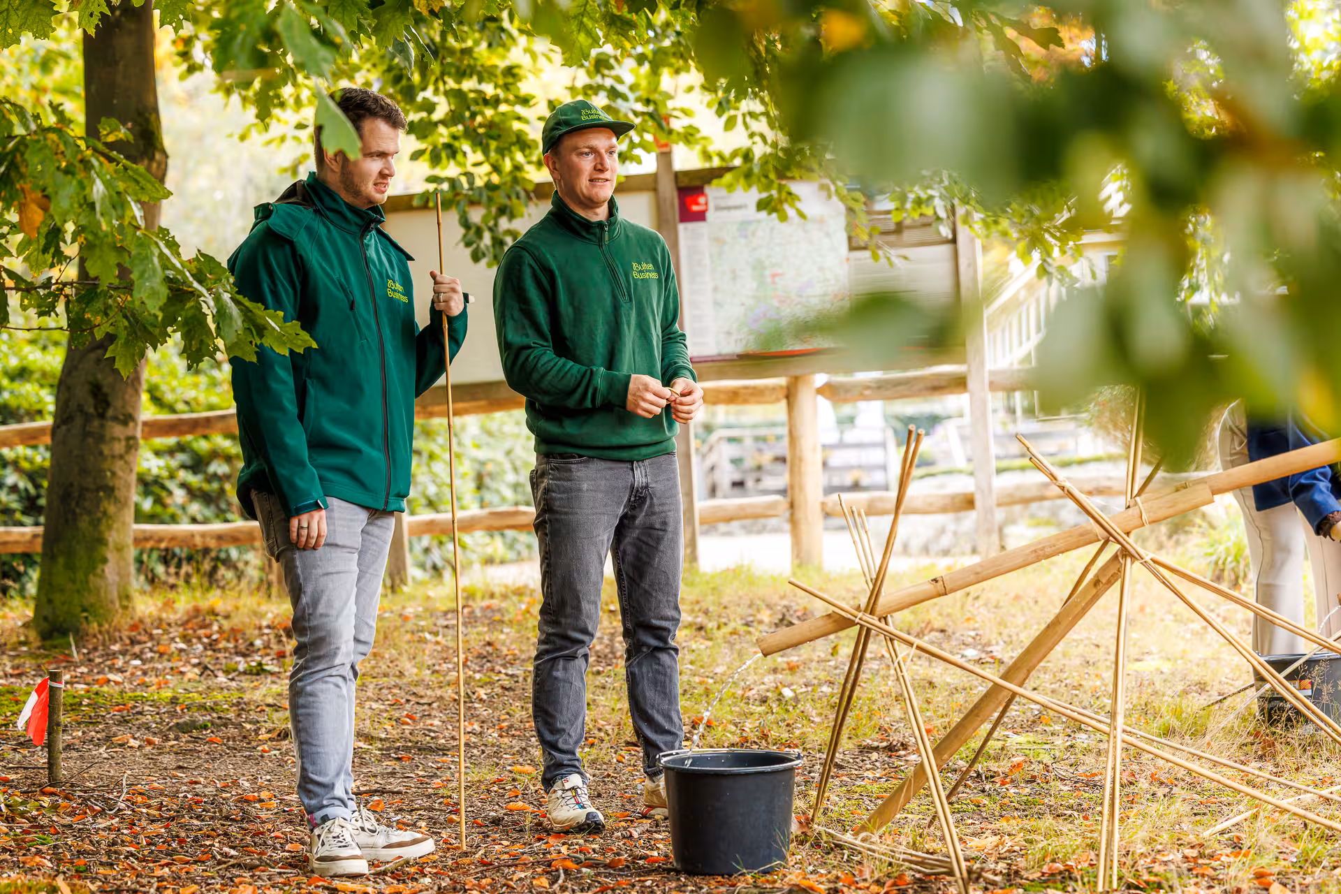Twee BuitenBusiness instructeurs staan naast elkaar in een bosrijke omgeving
