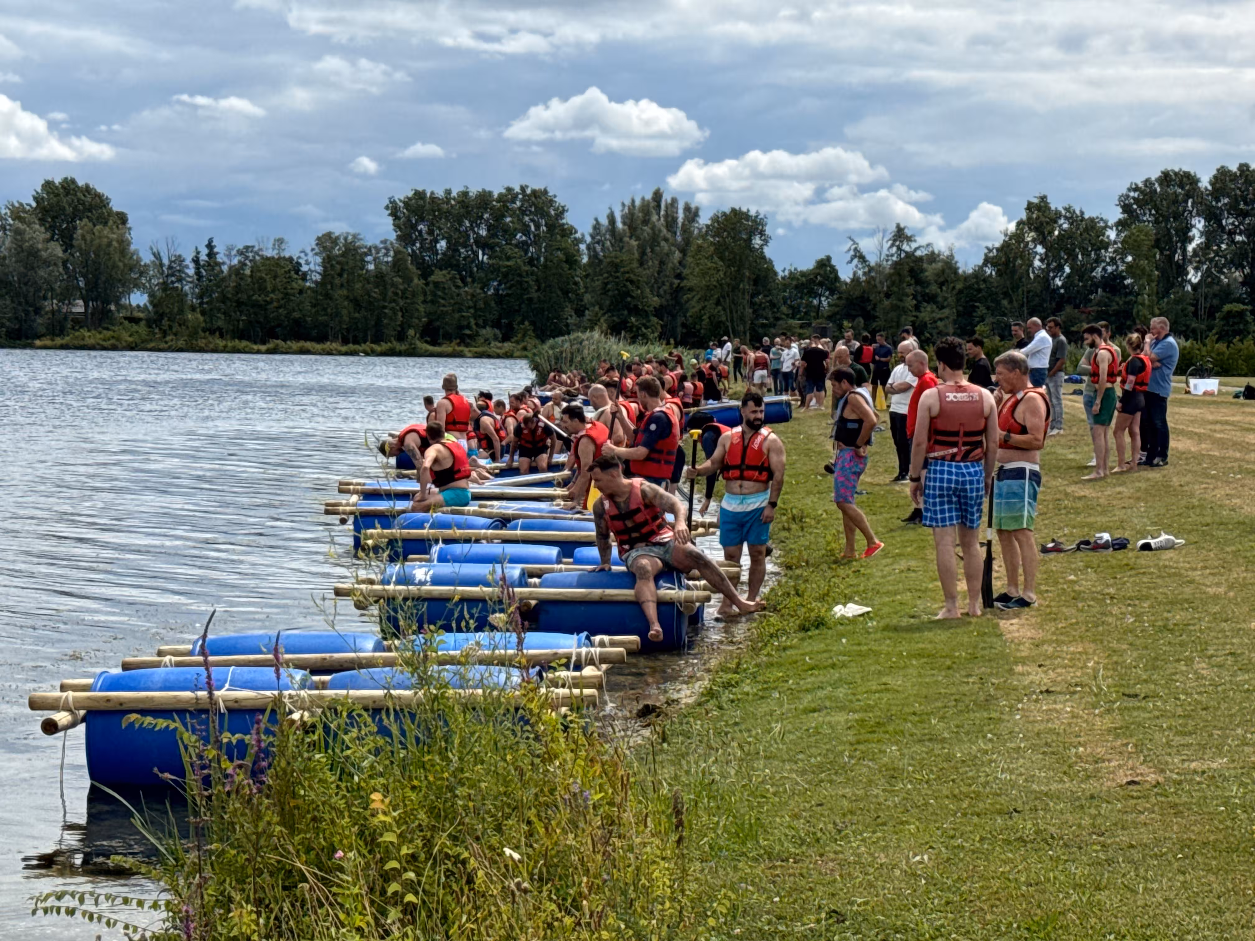 De vlotten met blauwe tonnen liggen in het water en de deelnemers gaan met een zwemvest er naar toe