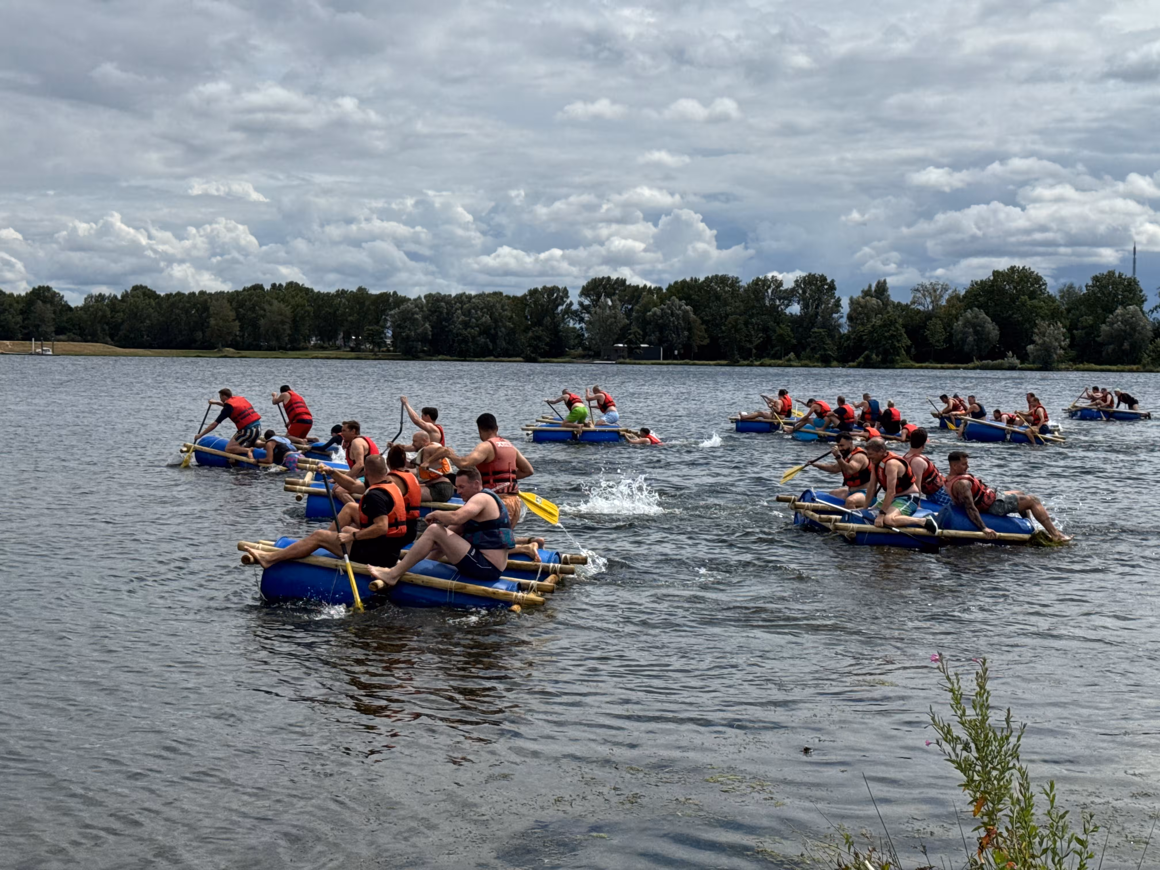 Verschillende vlotten zijn aan het varen op het water met gele peddels