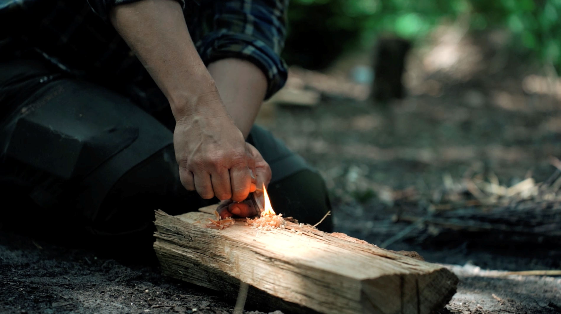 iemand probeert vuur te maken met hout