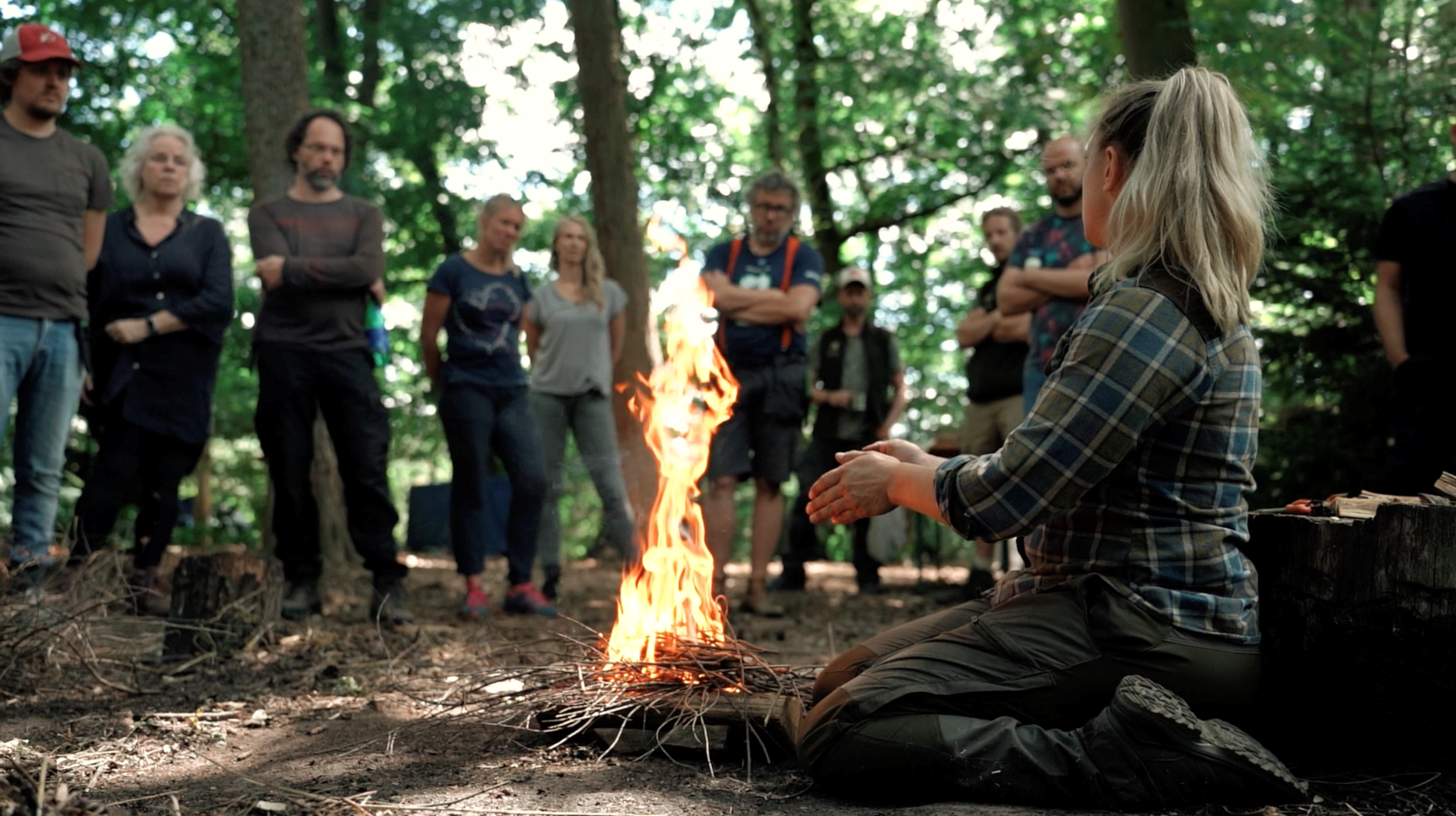 groep mensen staat rondom het vuur in het bos