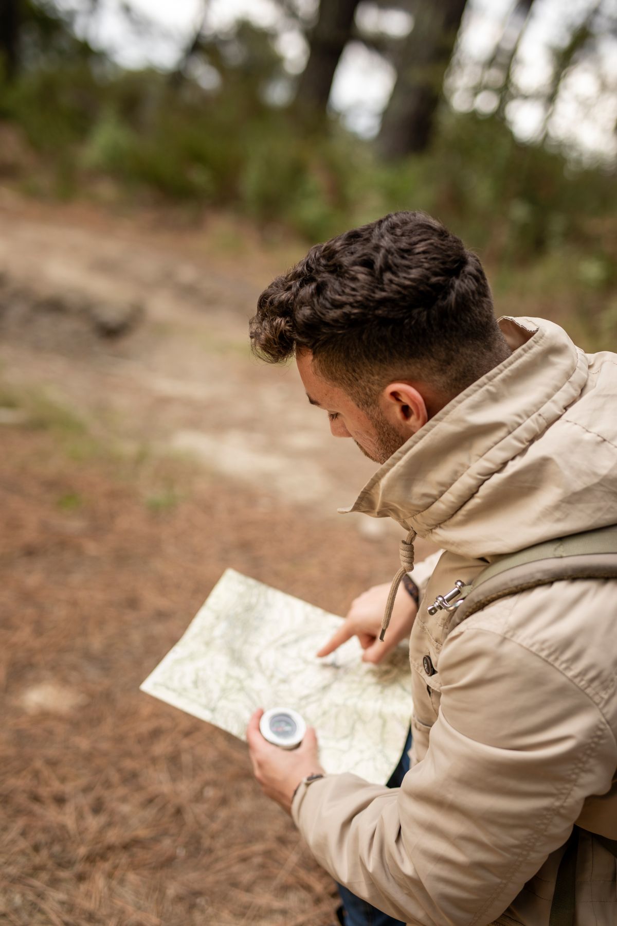 man staat in het bos en leest een kaart