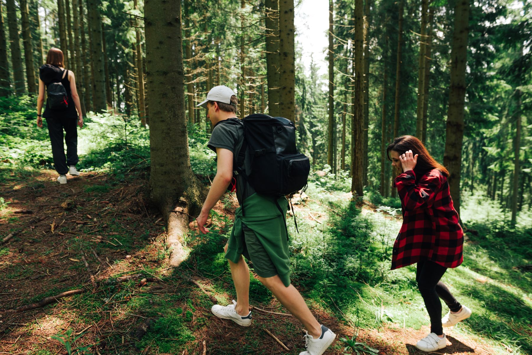 Drie mensen lopen in het bos tijdens opdracht Kompas Wandeling