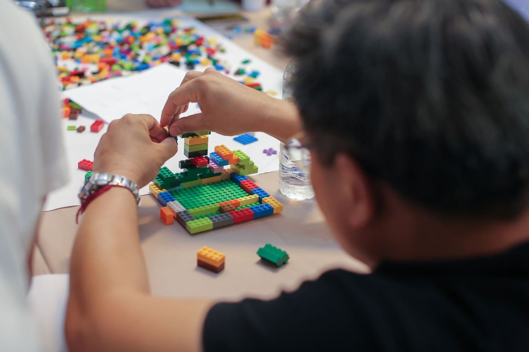 Man speelt aan tafel Lego Serious Play