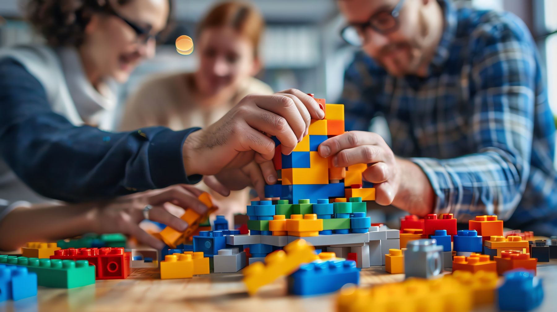 Mensen bouwen samen aan een bouwwerk van grote lego duplo blokken