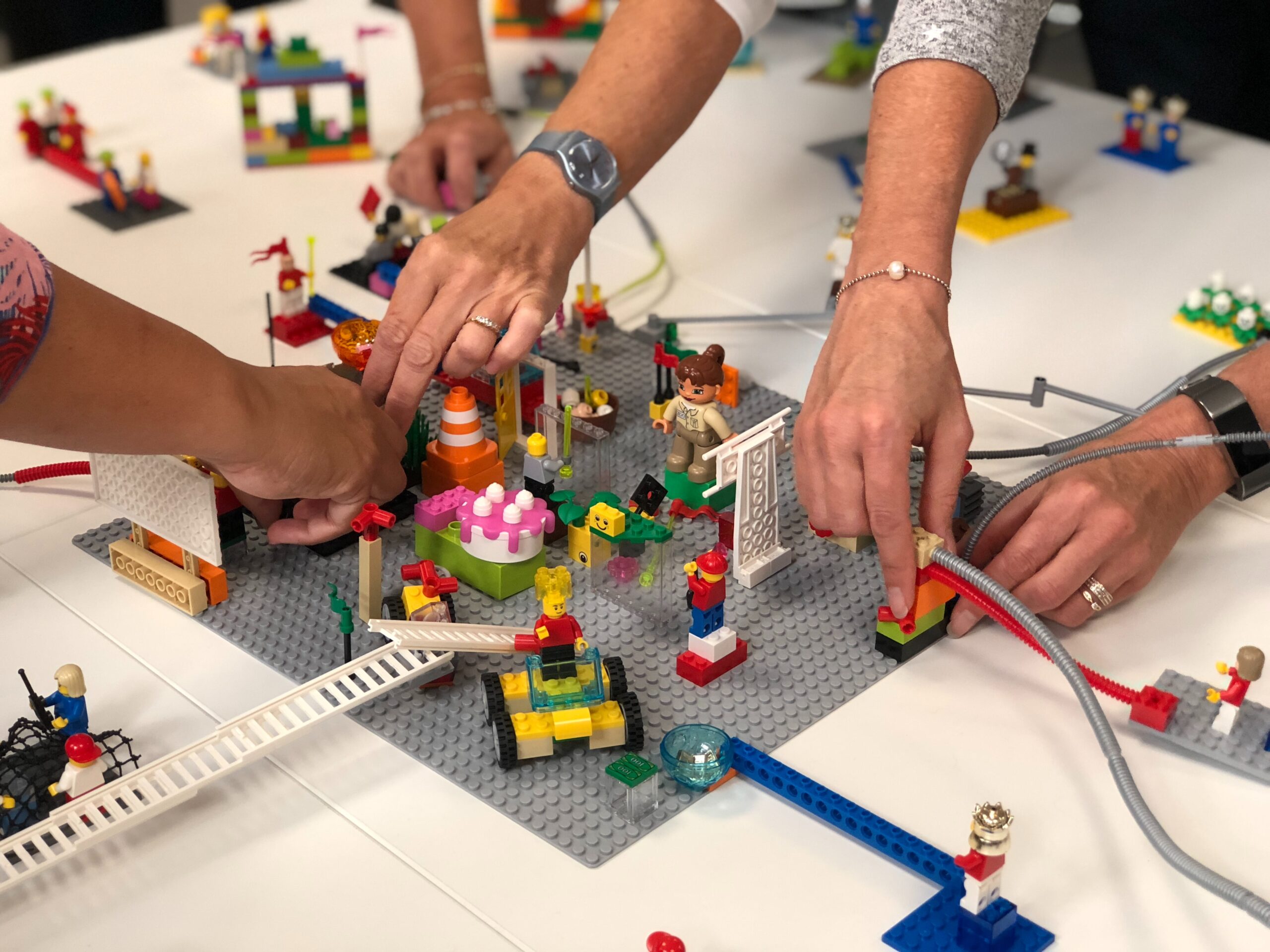 Handen die samen bouwen aan een Lego Serious Play bouwwerk