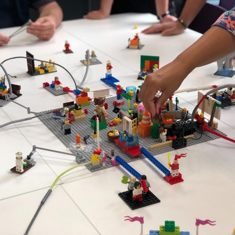 Mensen bouwen aan een situatie met lego stenen tijdens Lego Serious Play workshop
