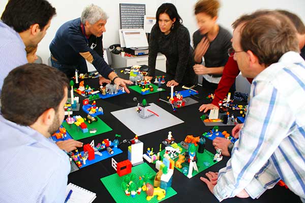 Acht mensen met instructeur Lego Serious Play workshop