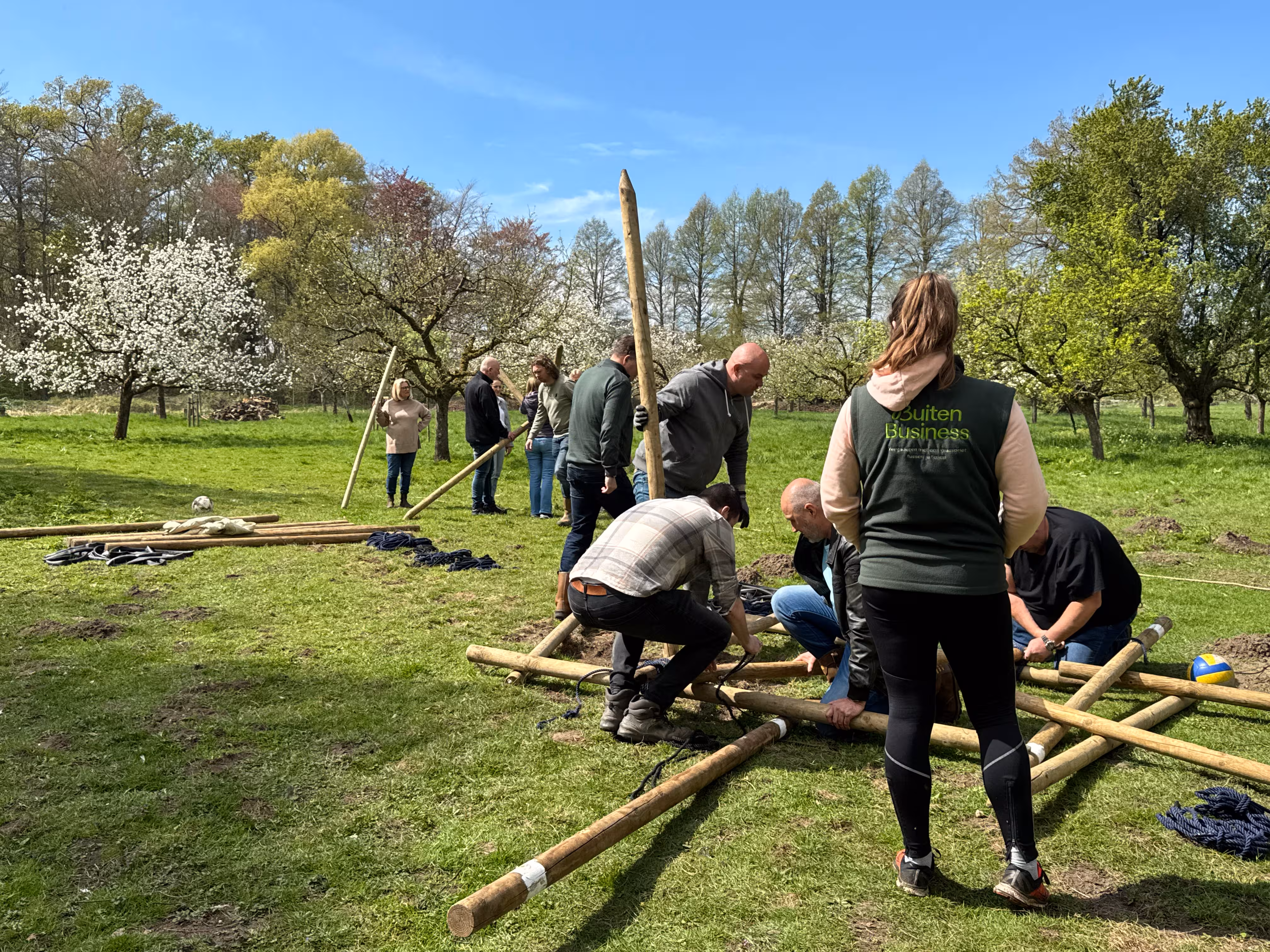 De BuitenBusiness instructeur kijkt naar de twee teams die bezig zijn met het bouwen van een katapult