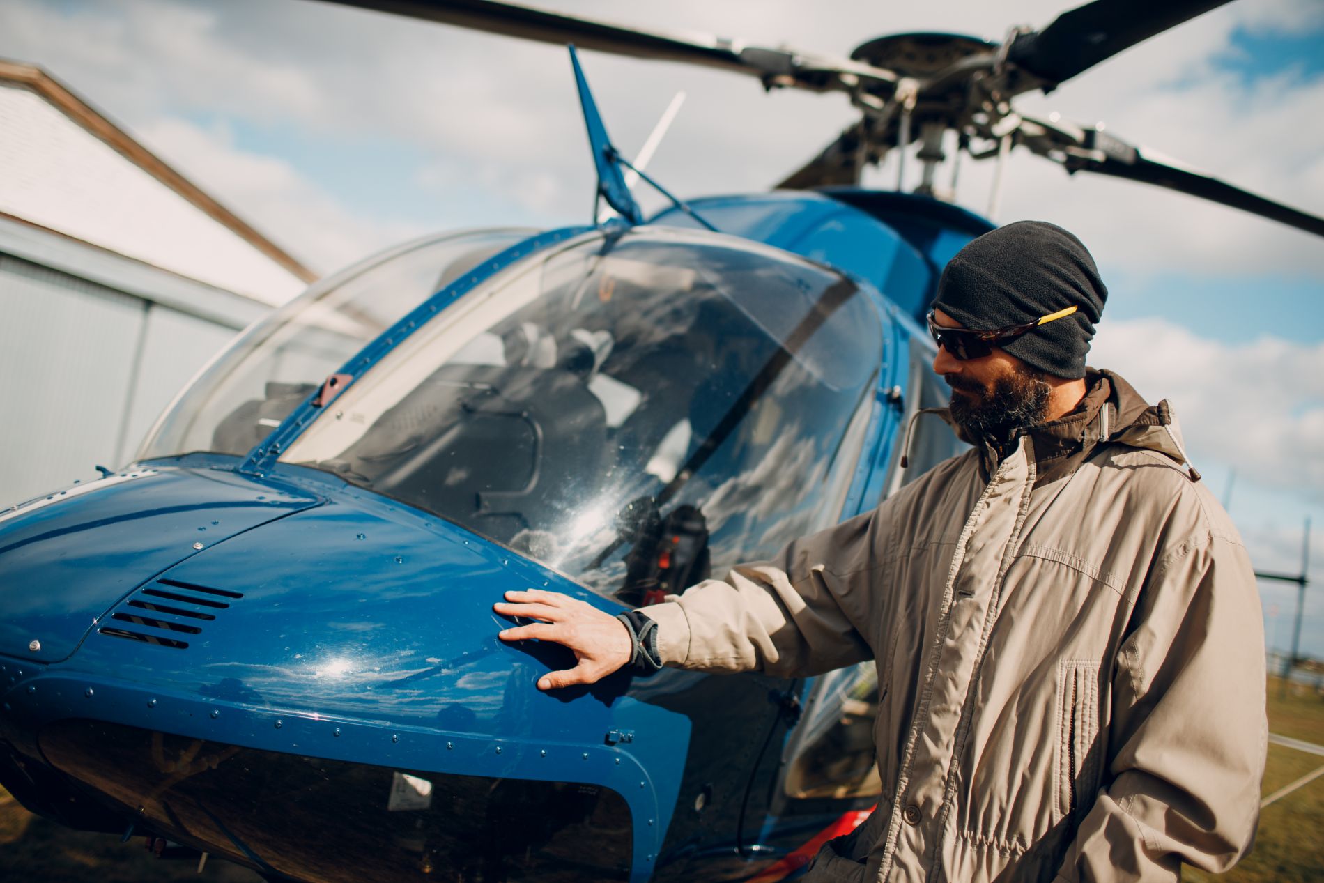 Man staat naast helikopter en legt zijn hand er op