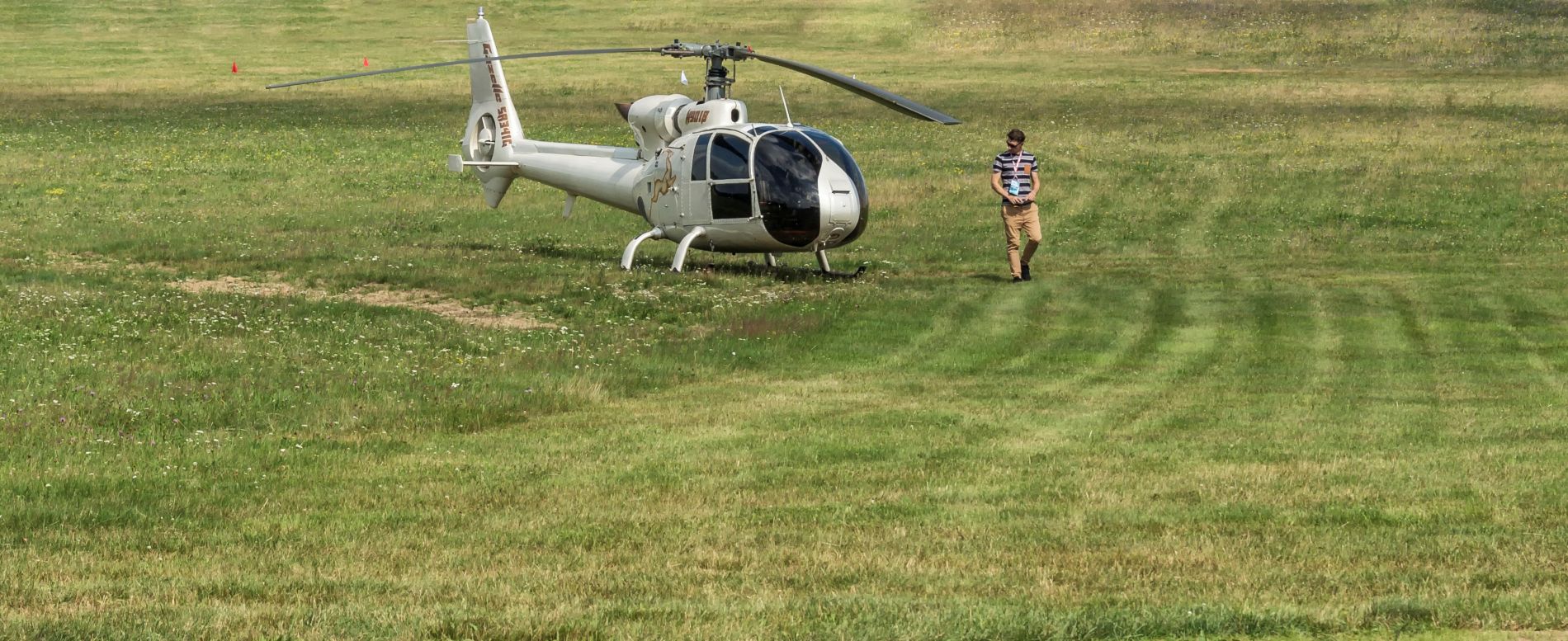 Helikopter op het gras met man ernaast