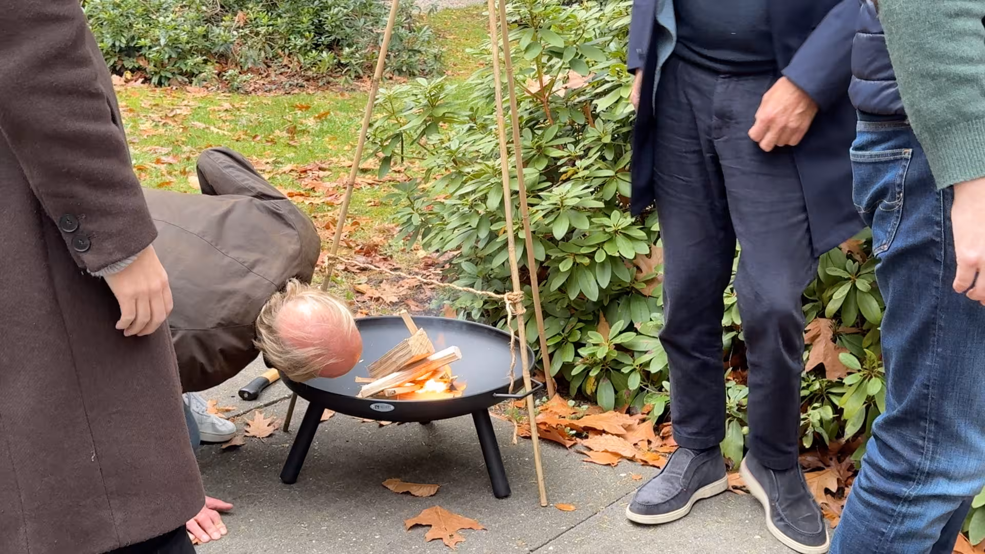 Een man zit met zijn hoofd dicht bij het vuur in de vuurschaal tijdens een workshop spelen met vuur door BuitenBusiness
