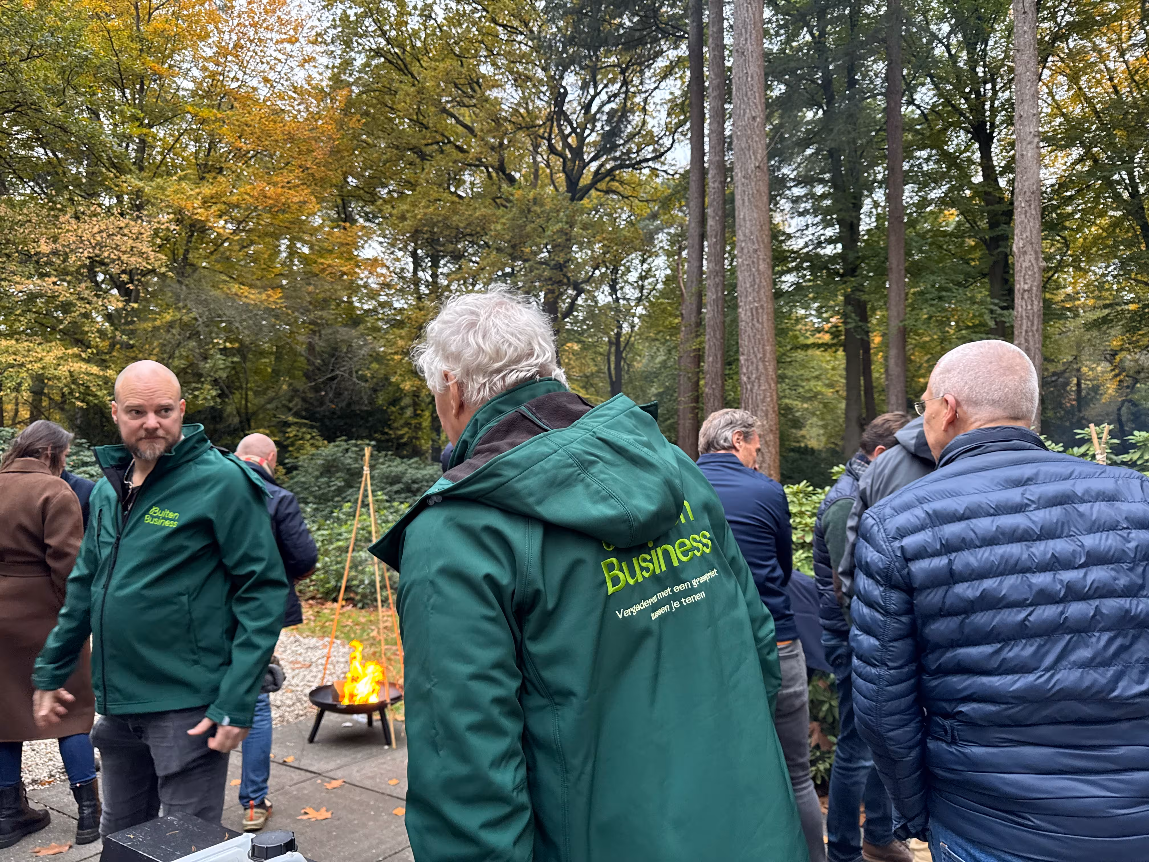 Twee BuitenBusiness instructeurs verzorgen de workshop vuur maken in een bosrijke omgeving