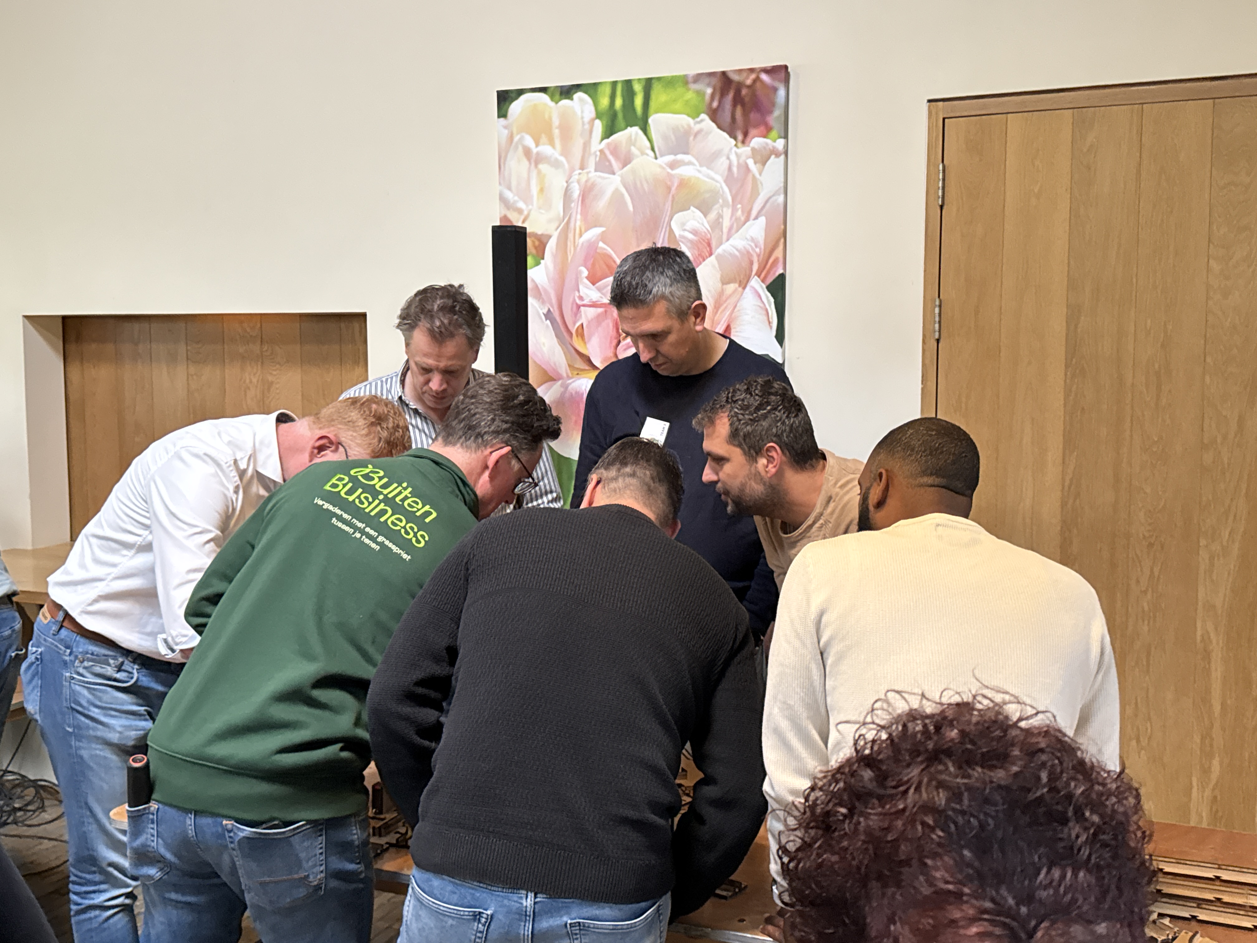 De BuitenBusiness instructeur staat bij een groep mannen die meekijken tijdens de duurzame chain reaction