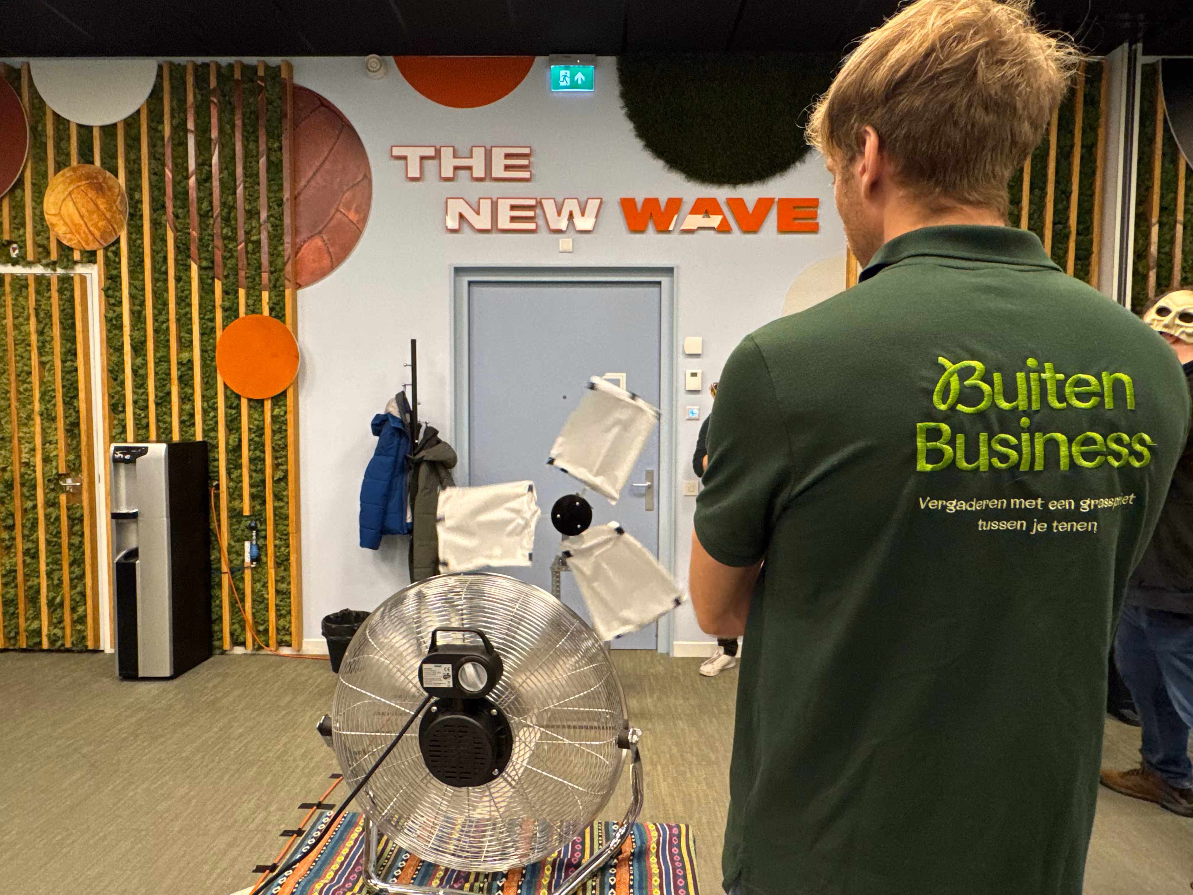 BuitenBusiness instructeur staat bij een ventilator en een windmolen met witte wieken