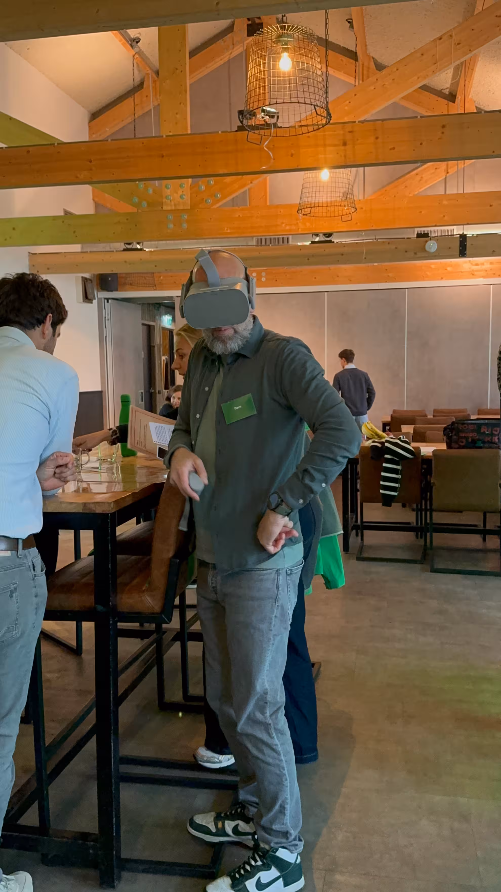 Een man staat aan tafel met een VR bril op tijdens een VR moordspel