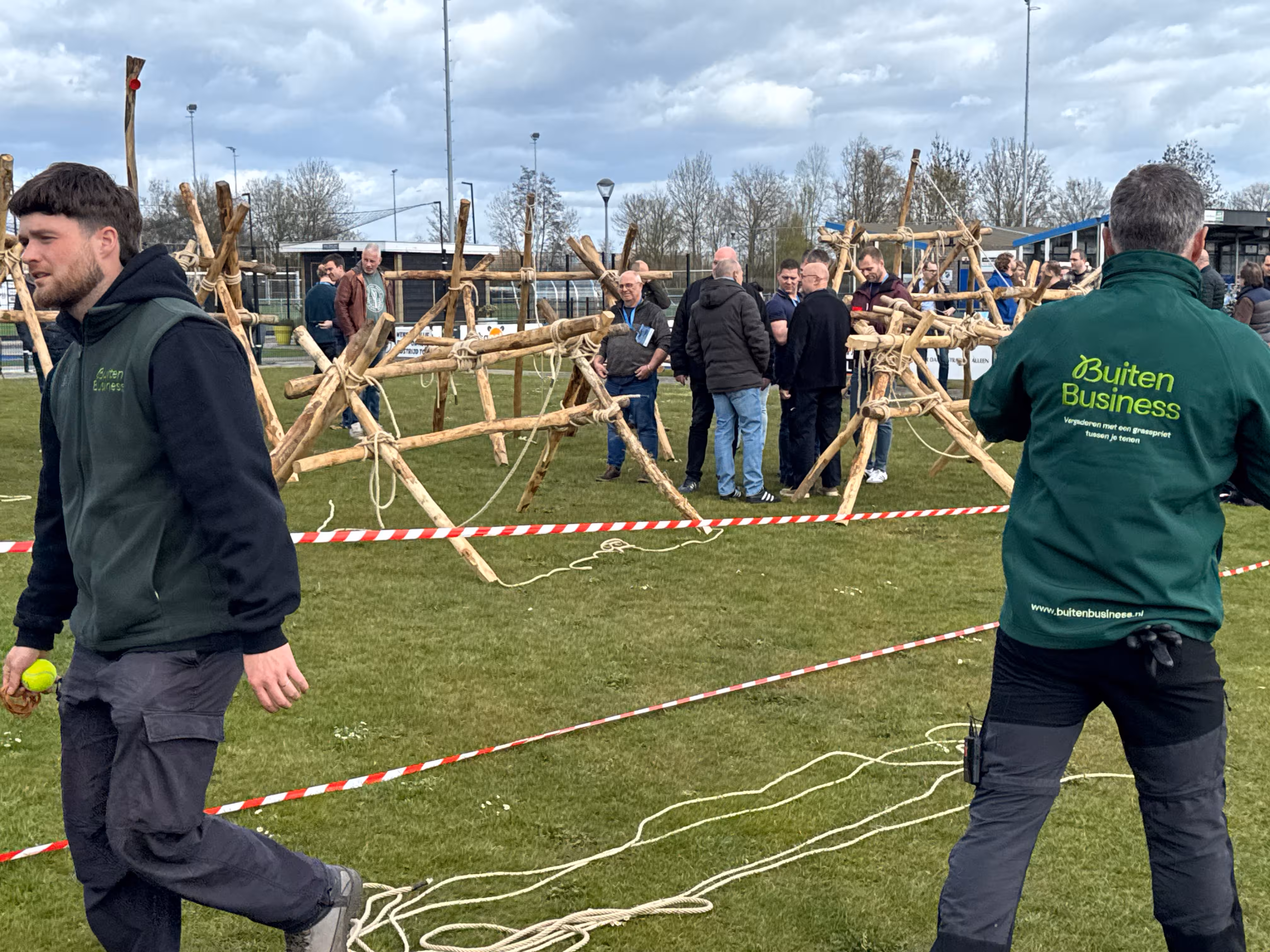 De BuitenBusiness instructeur observeert de deelnemers die deelnemen aan de workshop katapult bouwen