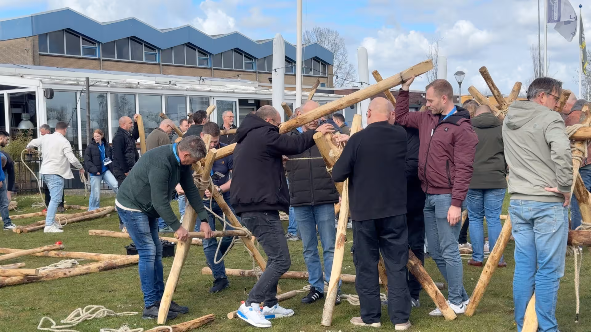 Op een grasveld worden met houten balken en touw een katapult gemaakt