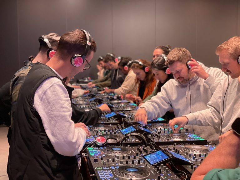 De deelnemers focussen zich op het mixen van de nummers tijdens de DJ Workshop