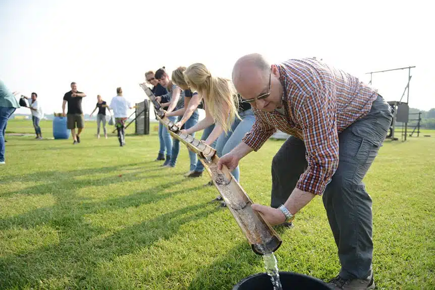 groep mensen vervoert water in goot tijdens Alleskunner Teambuilding door BuitenBusiness