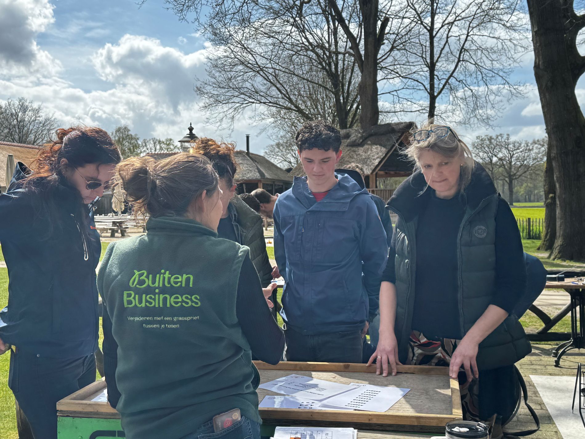 Instructeur van BuitenBusiness deelt onderdelen uit die gewonnen zijn tijdens de veiliging Bouw een fiets voor Afrika