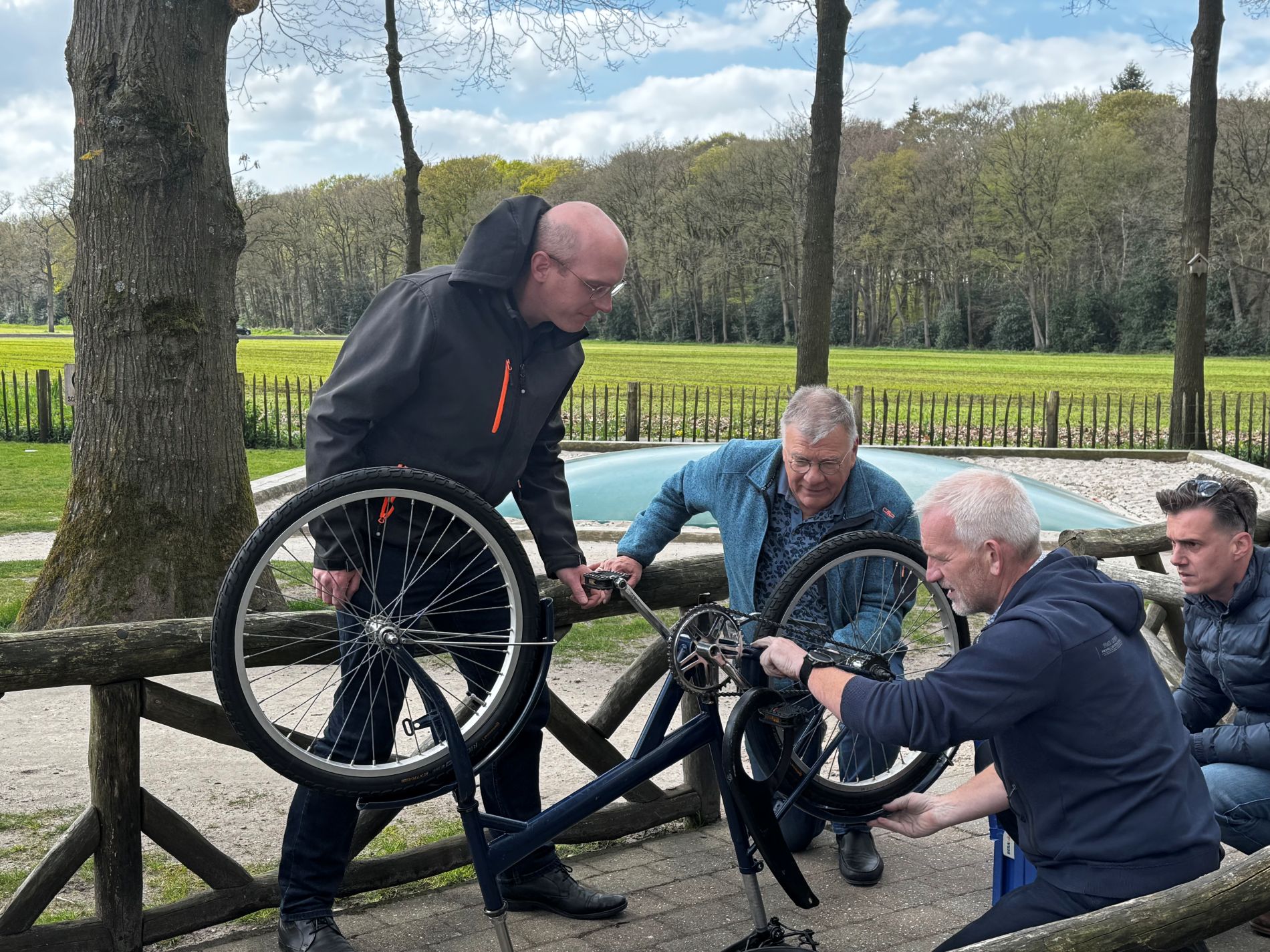 Groep mensen bouwen aan een fiets voor Afrika tijdens teambuilding door BuitenBusiness