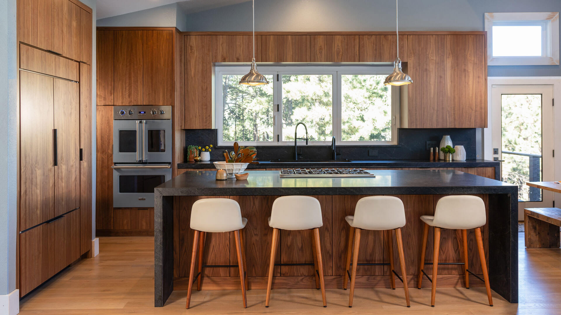 Modern kitchen with walnut and black cabinetry and open layout in Evergreen Colorado
