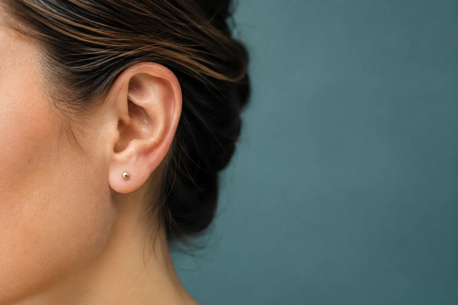 Landscape editorial close-up macro photograph of a human ear in soft natural window light, shallow depth of field, focus on