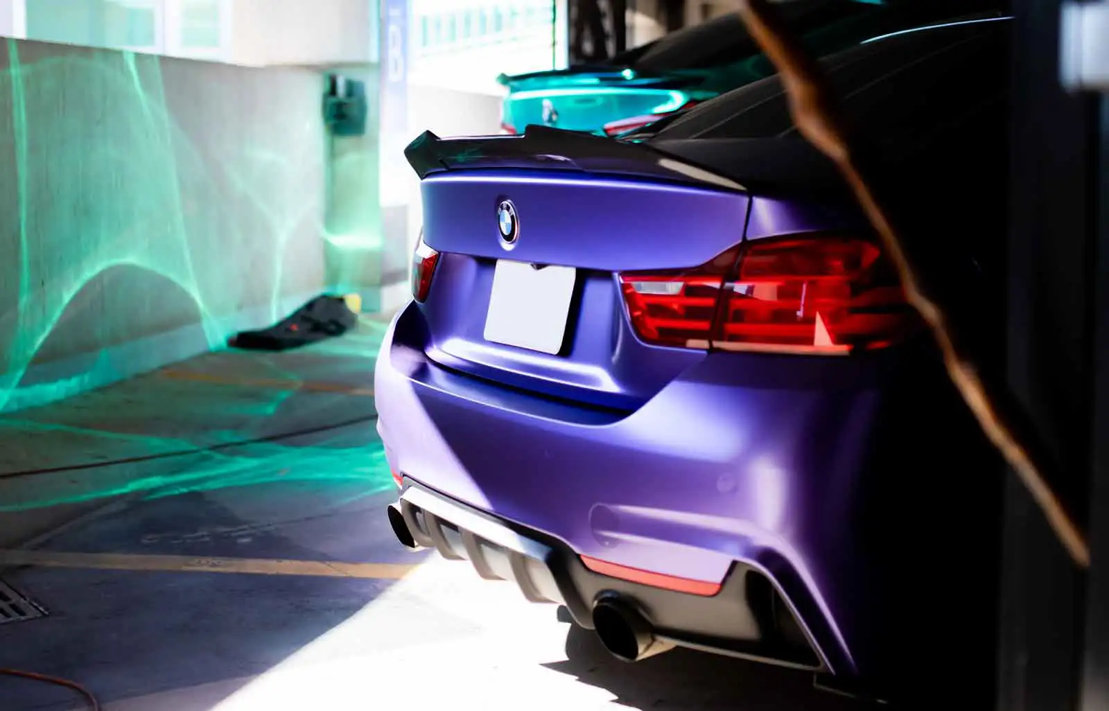 Technician installing paint protection film on the bumper of a Mercedes-Benz E-Class.