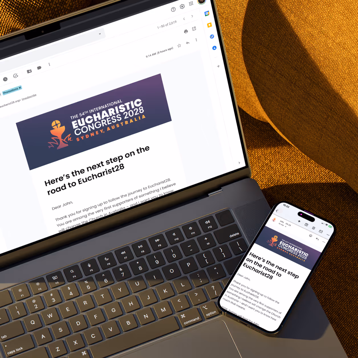 Laptop and smartphone showing an email about the 54th International Eucharistic Congress 2028 in Sydney.