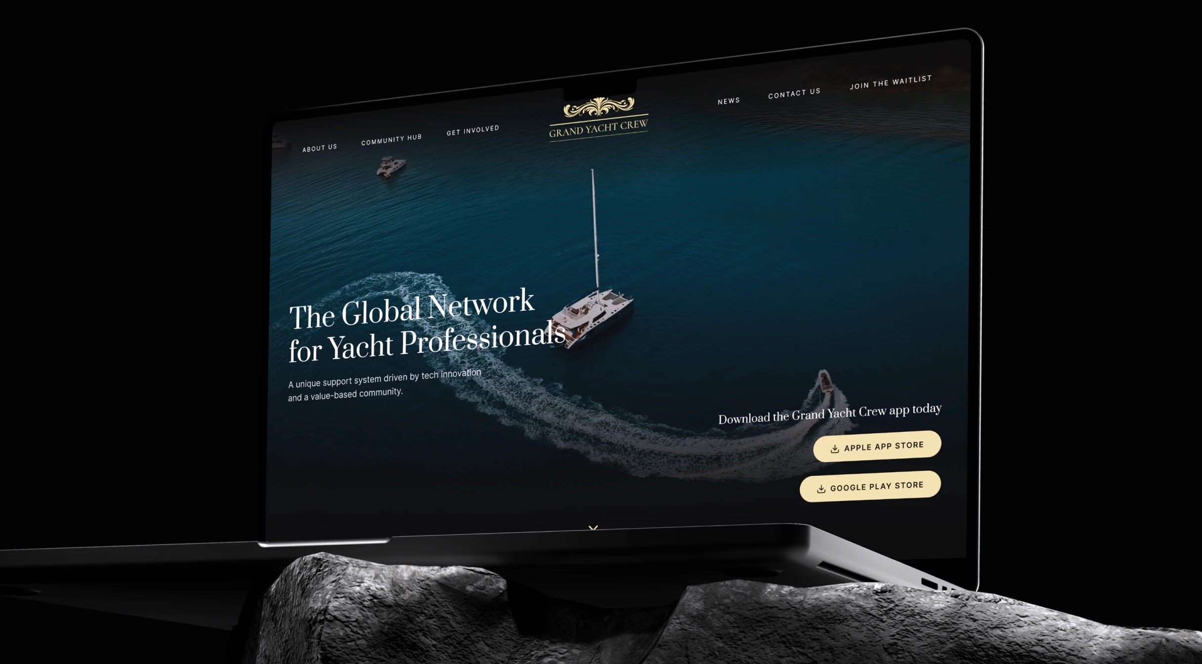 Laptop screen showing Grand Yacht Crew website with yacht and boat on blue water in background.