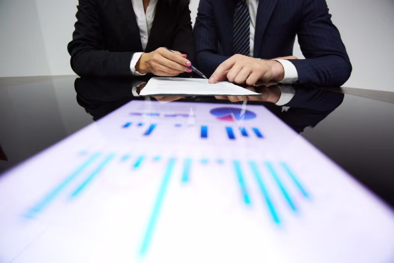 Two colleagues review a tablet displaying a chart about increasing ERP consultant costs projected for 2025.