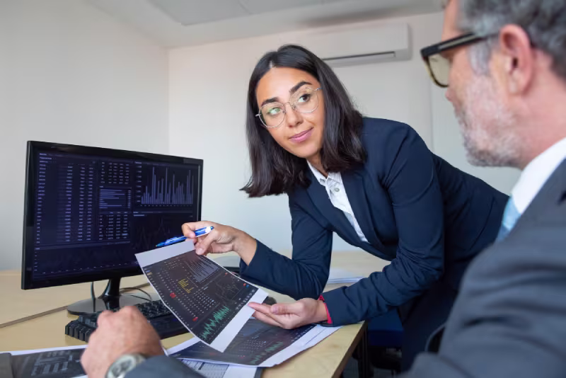 Businesswoman and man collaborating on a business strategy in an office, focusing on ongoing NetSuite administrator costs.
