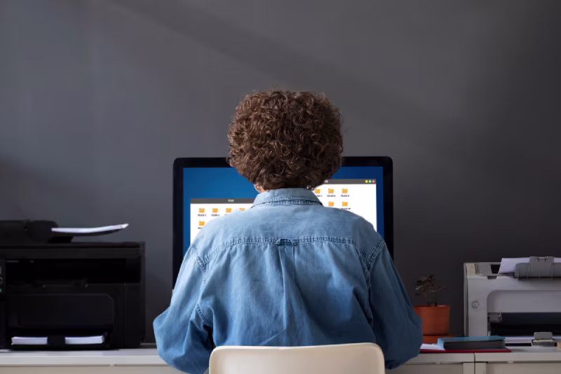 A person at a desk using a computer, representing the top benefits of hiring a remote NetSuite developer.