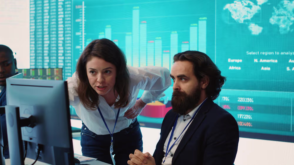 Group of three analyzing a computer screen about the pros and cons of outsourced versus full-time NetSuite administrators.