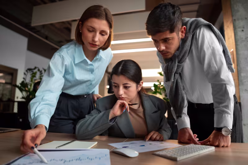 Three business professionals reviewing a document related to NetSuite Administrator gaps and solutions.