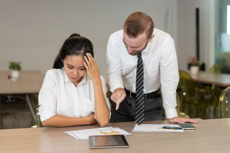 A man and woman sit at a table, examining documents related to the ROI of addressing existing gaps in their work.