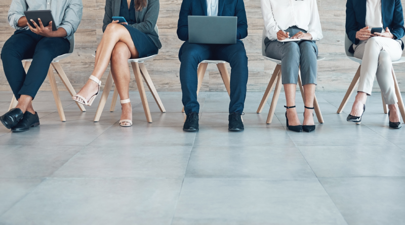 Business professionals collaborating on laptops while seated, discussing strategies for quality with offshore teams