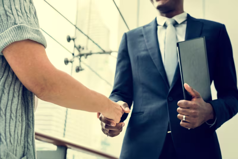 Two professionals shake hands, representing collaboration in hiring offshore NetSuite developers for 2026 strategies.