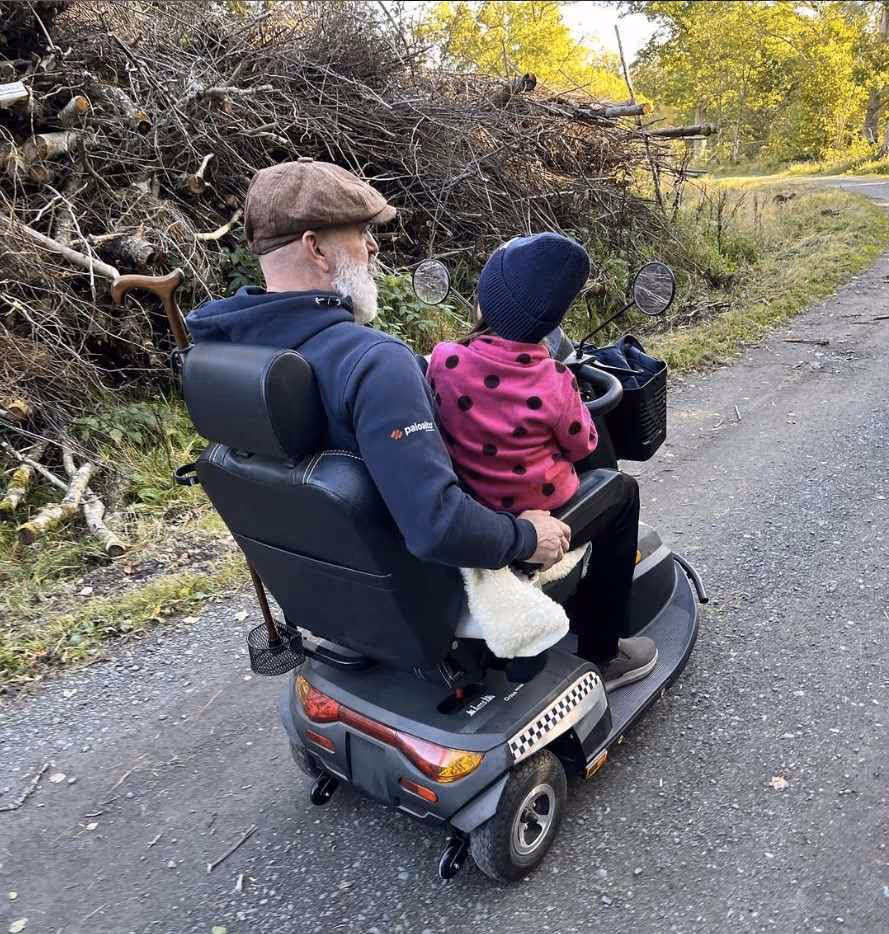 Pelle Plym med sitt barnbarn i knät.