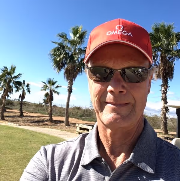 Anders står framför palmer och har på sig keps och solglasögon.